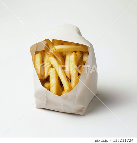 A brown paper bag filled with golden, crispy French fries is shown against a white background. A brown paper bag filled with golden, crispy French fries is shown against a white background. 135211724
