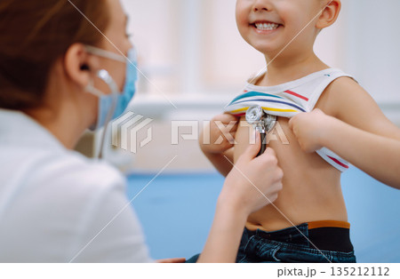 Female Doctor examining a little boy by stethoscope. ?hild's health Female Doctor examining a little boy by stethoscope. ?hild's health 135212112