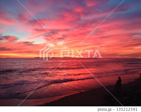 夕焼けの海で遊ぶ子供 135212591