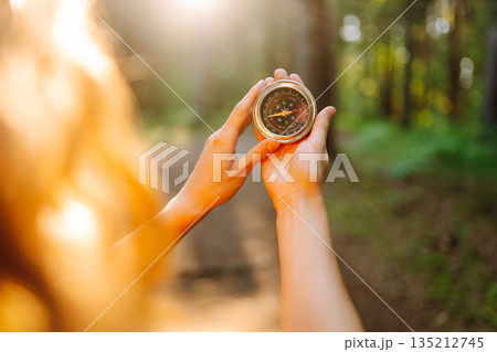 Hands of woman holding navigational compass. Female traveler holding compass in hands 135212745