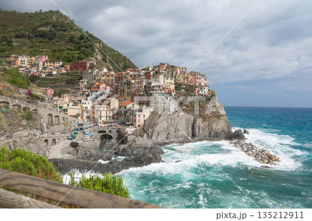 Colorful houses of a coastal town built on steep rocky cliffs above the sea. Popular travel destination and Mediterranean landscape 135212911
