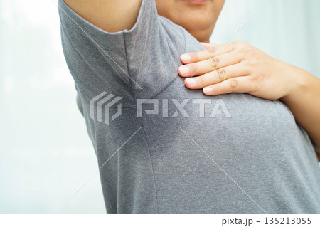 Sweaty underarms, Asian woman with sweat on clothes under armpit. Sweaty underarms, Asian woman with sweat on clothes under armpit. 135213055