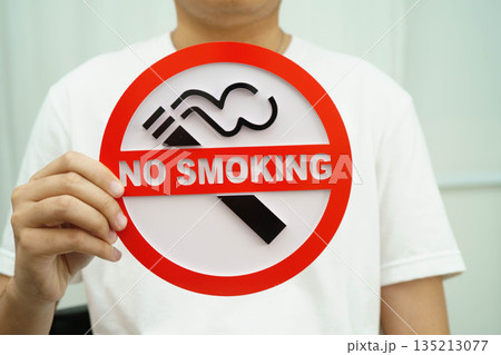 Male holding a no smoking sign. 135213077