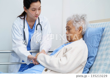 Asian doctor checking and treat elderly woman patient health in hospital. Asian doctor checking and treat elderly woman patient health in hospital. 135213229