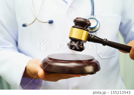 Asian doctor holding court hammer for and crime law justice, forensic medicine. 135213543