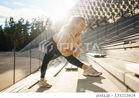 Young woman in sportswear is training outdoors. Sports concept, healthy body. Young woman in sportswear is training outdoors. Sports concept, healthy body. 135213614