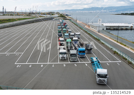 大阪・夢洲コンテナターミナルに整然と並ぶトレーラーとIR建設予定地の遠景(物流・2024年問題) 大阪・夢洲コンテナターミナルに整然と並ぶトレーラーとIR建設予定地の遠景(物流・2024年問題) 135214529