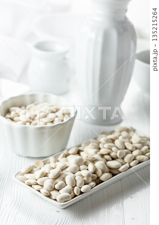 Dried white beans on a white table. Dried white beans on a white table. 135215264