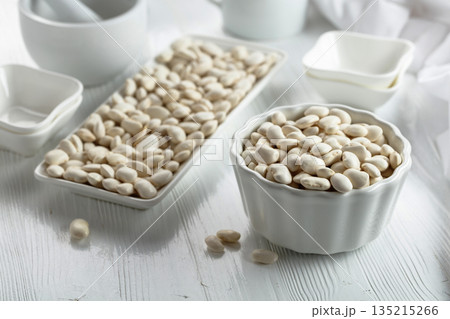 Dried white beans on a white table. Dried white beans on a white table. 135215266