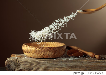 Rice is poured into a wicker bowl. Rice is poured into a wicker bowl. 135215274