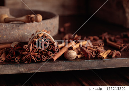 Cinnamon sticks, anise, and nutmeg on a wooden table. 135215292