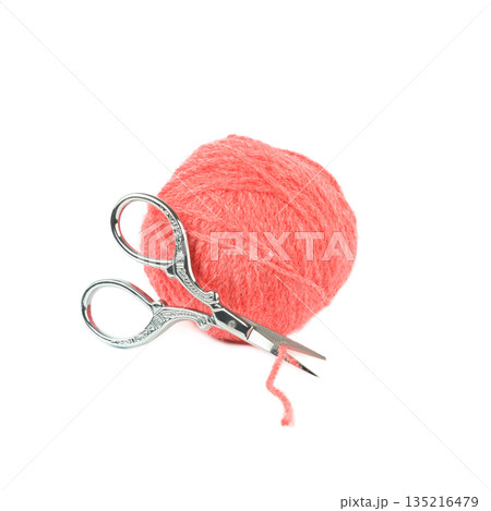 Pink wool yarn ball with ornate silver scissors isolated on white 135216479