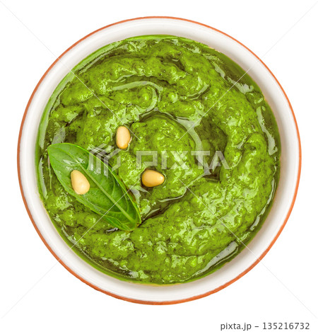 Fresh basil pesto sauce with pine nuts in ceramic bowl isolated on white background, top view Fresh basil pesto sauce with pine nuts in ceramic bowl isolated on white background, top view 135216732