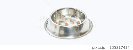 Empty stainless steel pet bowl with food residue on white background 135217434