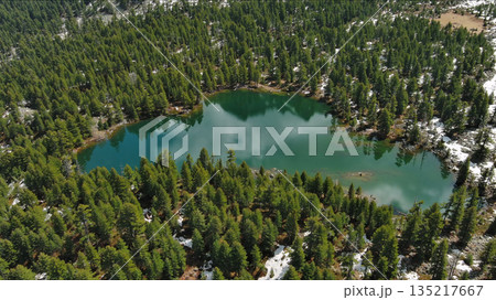 Mountain lake with snow mountains and green forest Mountain lake with snow mountains and green forest 135217667