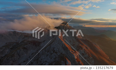 Amazing rocky mountains in clouds at sunset 135217679