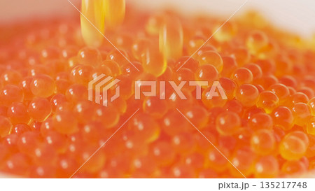 Falling red caviar closeup macro view Falling red caviar closeup macro view 135217748