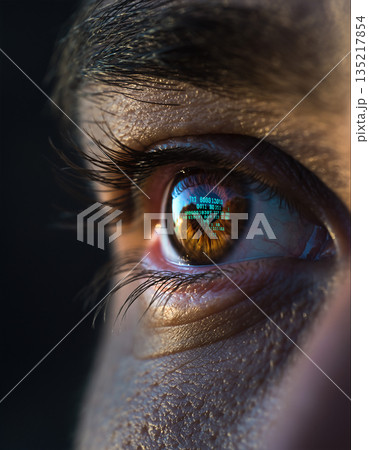 Close view of an eye showing computer code reflected on the surface during a late evening study session 135217854