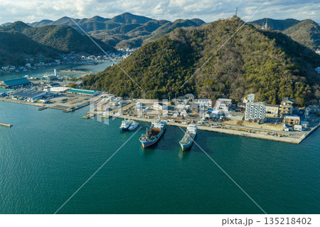 冬の岡山県日生町 情緒ある漁港と山並みに囲まれた港町の町並み空撮 135218402