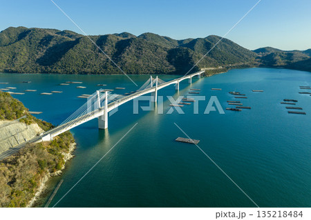 冬の備前日生大橋と瀬戸内海に広がる牡蠣養殖いかだの空撮風景 岡山県 135218484