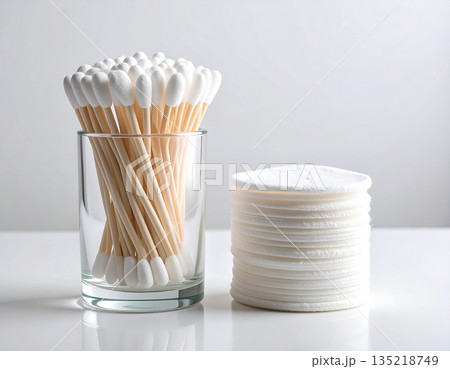 Hygiene cotton tools. White cotton swabs and reusable cotton pads neatly stacked on a white background. 135218749