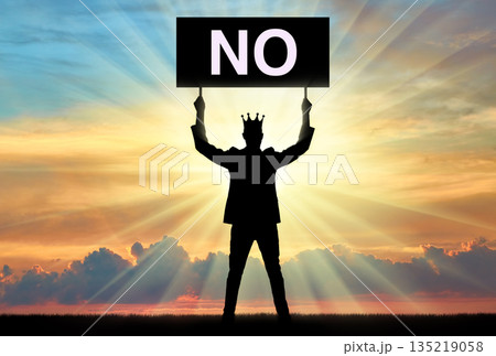 Selfishness. Selfish man with a crown on his head, holding a poster with the word no. Selfishness. Selfish man with a crown on his head, holding a poster with the word no. 135219058