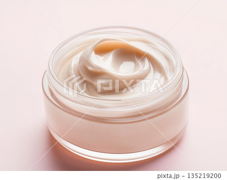 Creamy skincare product in clear jar showcasing smooth texture with copy space for branding 135219200