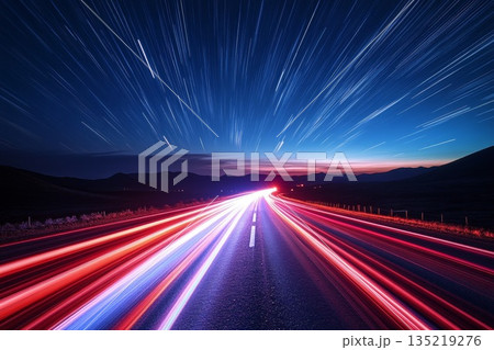 Glowing red and white light trails crossing dark road under starry night sky Glowing red and white light trails crossing dark road under starry night sky 135219276