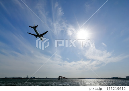 強い日差しと着陸する飛行機の影 強い日差しと着陸する飛行機の影 135219612