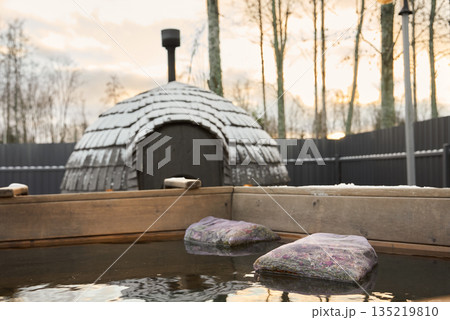 Calming outdoor bathing area with natural surroundings and warm lighting Calming outdoor bathing area with natural surroundings and warm lighting 135219810