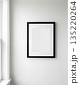 Blank picture frame on white wall in minimalist interior 135220264