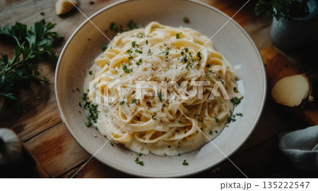 Creamy fettuccine pasta served with herbs and cheese on a rustic wooden table Creamy fettuccine pasta served with herbs and cheese on a rustic wooden table 135222547