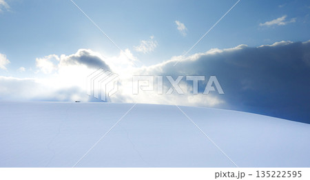 真冬の北海道美瑛町の丘の上から見た雪原に太陽が沈む風景 135222595