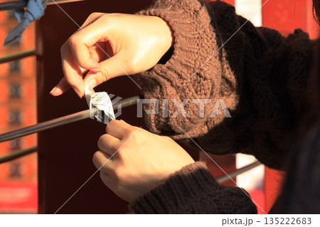 おみくじを結ぶ手　願掛け 135222683