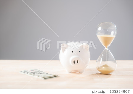 Piggy bank, money, and hourglass represent saving time and financial investment, a crucial concept for future planning and smart business strategies, securing retirement wealth 135224907