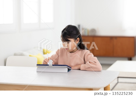 タブレットで学習する小学生の女の子 タブレットで学習する小学生の女の子 135225230