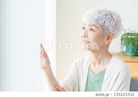 窓の外を見るシニア女性 135225532