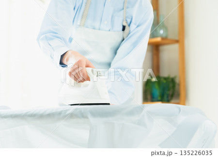 ワイシャツのアイロン掛けをする女性の手元 135226035