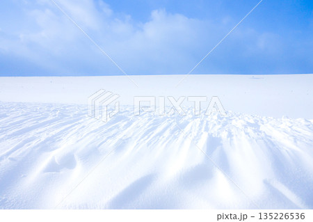 風の強い真冬の北海道によく見られる雪原にできた風紋 135226536