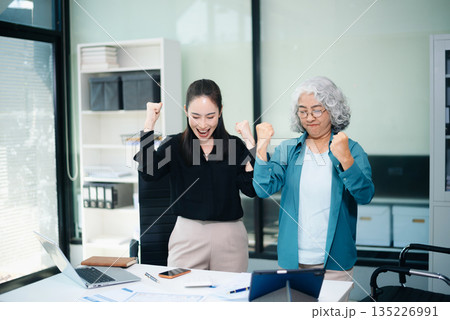 Happy Asian businesswomen celebrating teamwork success in office. Corporate achievement, business victory, motivation 135226991