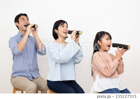 恵方巻きを丸かぶりする3人家族 恵方巻きを丸かぶりする3人家族 135227315