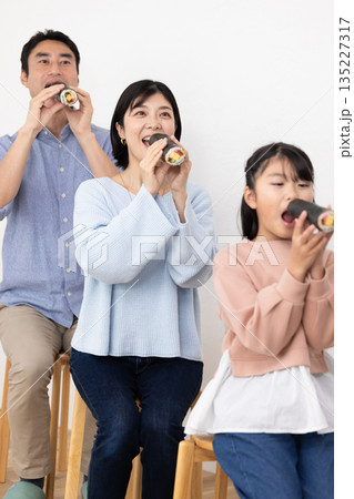恵方巻きを丸かぶりする3人家族 135227317
