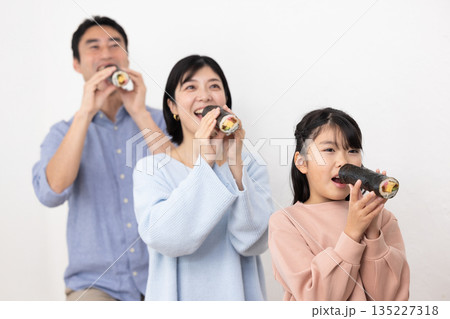 恵方巻きを丸かぶりする3人家族 135227318