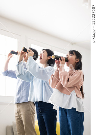 明るいリビングで恵方巻きを丸かぶりする3人家族 明るいリビングで恵方巻きを丸かぶりする3人家族 135227587