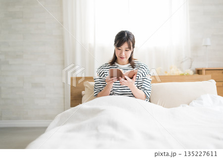 ベッドで読書をする女性 135227611