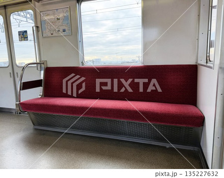 通勤電車の赤い生地が貼られたロングシート 135227632