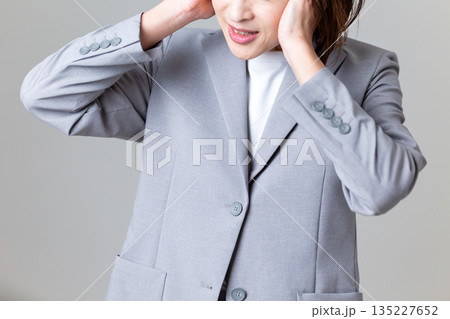 耳を塞ぐミドル女性ビジネスウーマン 耳を塞ぐミドル女性ビジネスウーマン 135227652