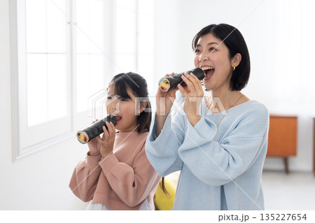 恵方巻きを丸かぶりする母親と娘 135227654