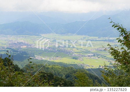 山頂から見下ろす緑豊かな田園風景と集落のパノラマ 135227820