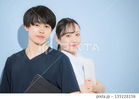 水色背景で爽やかな看護師イメージの若い男女　新卒採用や転職の求人などに　カメラ目線 135228156